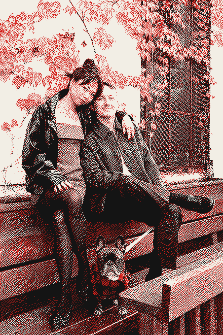 Alice and Brady on a bench under red ivy, with their French bulldog